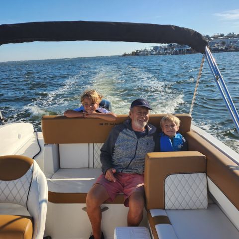 a group of people sitting in a boat on a body of water