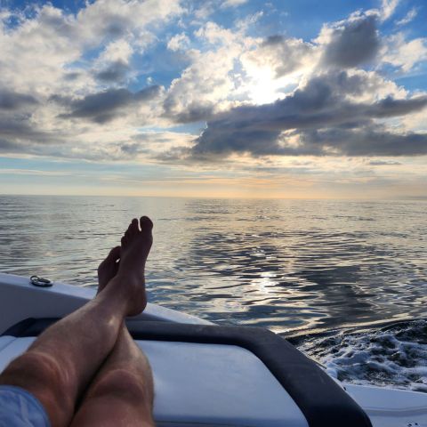 a man sitting next to a body of water