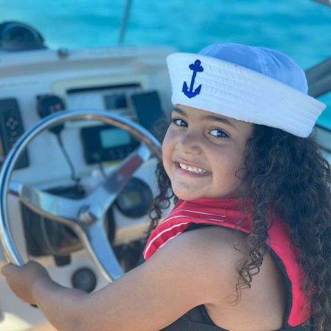 a little girl wearing a hat and sunglasses