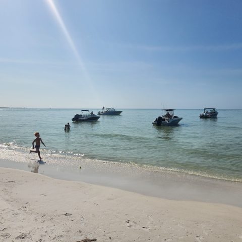 a group of people standing on top of a sandy beach