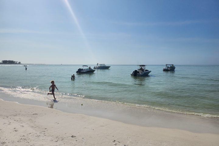 a group of people standing on top of a sandy beach