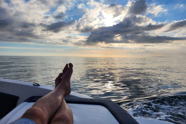 a person sitting on a beach near a body of water