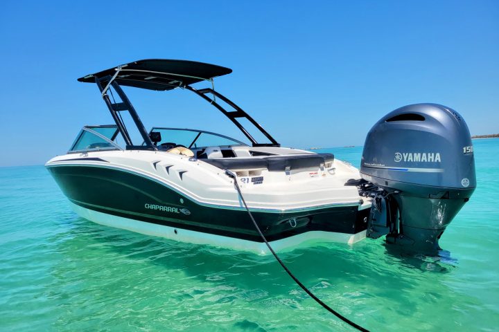 A 21-foot Chaparral Bow Rider boat rental in Sarasota, FL, floating on calm, turquoise waters, ideal for groups up to 8 people for cruising, fishing, and sandbar hopping.