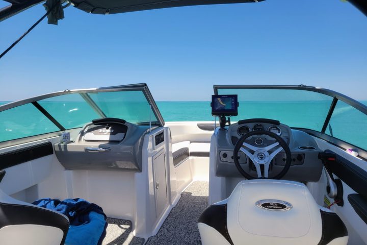 A 21-foot Chaparral Bow Rider boat rental in Sarasota, FL, floating on calm, turquoise waters, ideal for groups up to 8 people for cruising, fishing, and sandbar hopping.