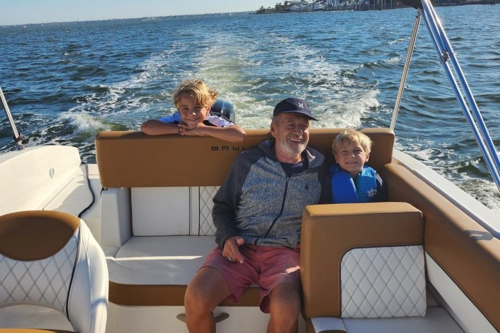 A few people on a Bayliner bowrider boat rental in Sarasota, FL, floating on calm, turquoise waters, ideal for family outings and versatile activities