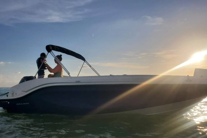 an adult and child on a bowrider boat rental in Sarasota enjoying a sunset