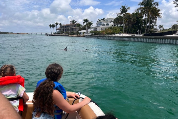 a group of young children sitting next to a body of water