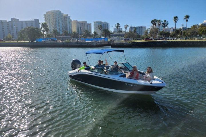 a small boat in a body of water with a city in the background