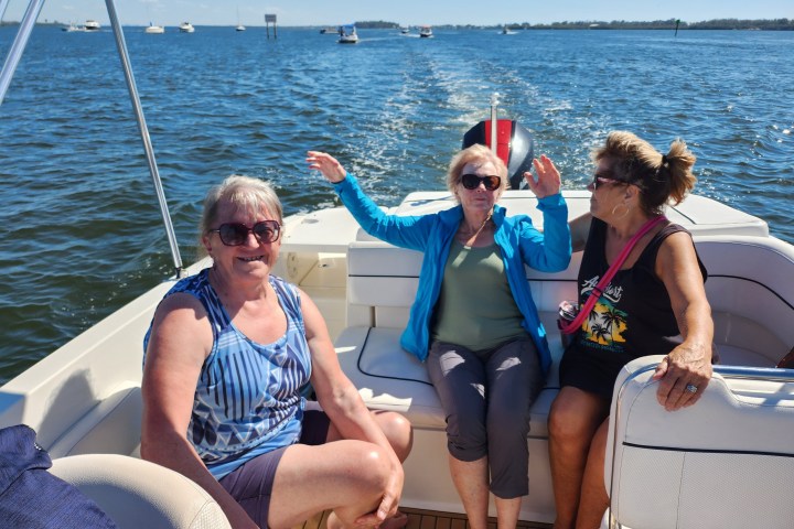 A 21-foot Chaparral Bow Rider boat rental in Sarasota, FL, riding on calm, turquoise waters