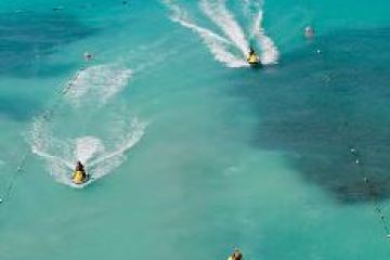 3 jet skis riding on the water