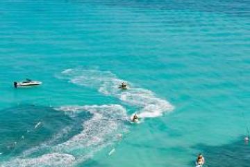 3 jet skis riding on the water