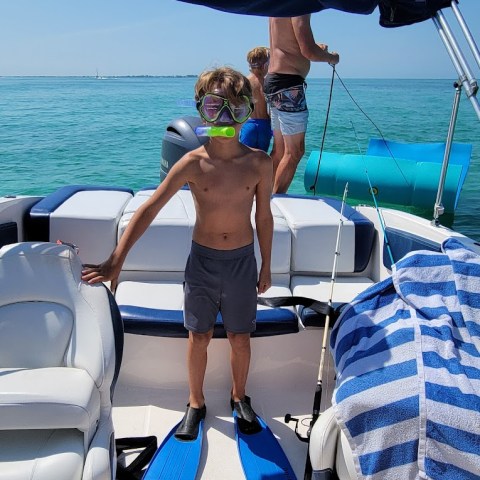 a person standing in front of a boat next to a body of water