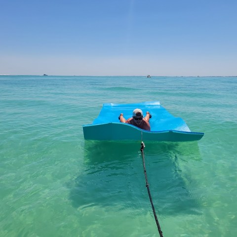 a man riding on the back of a boat in the ocean