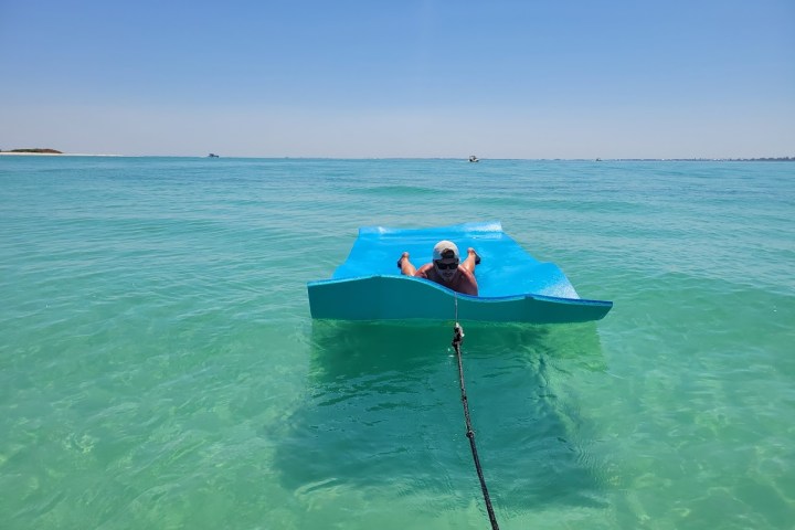 a man riding on the back of a boat in the ocean