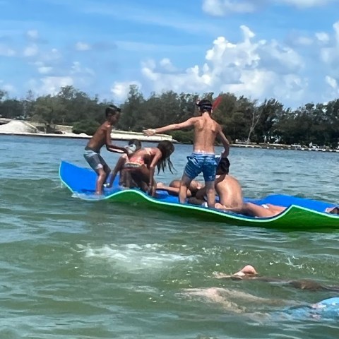 a group of people riding on the back of a boat in the water