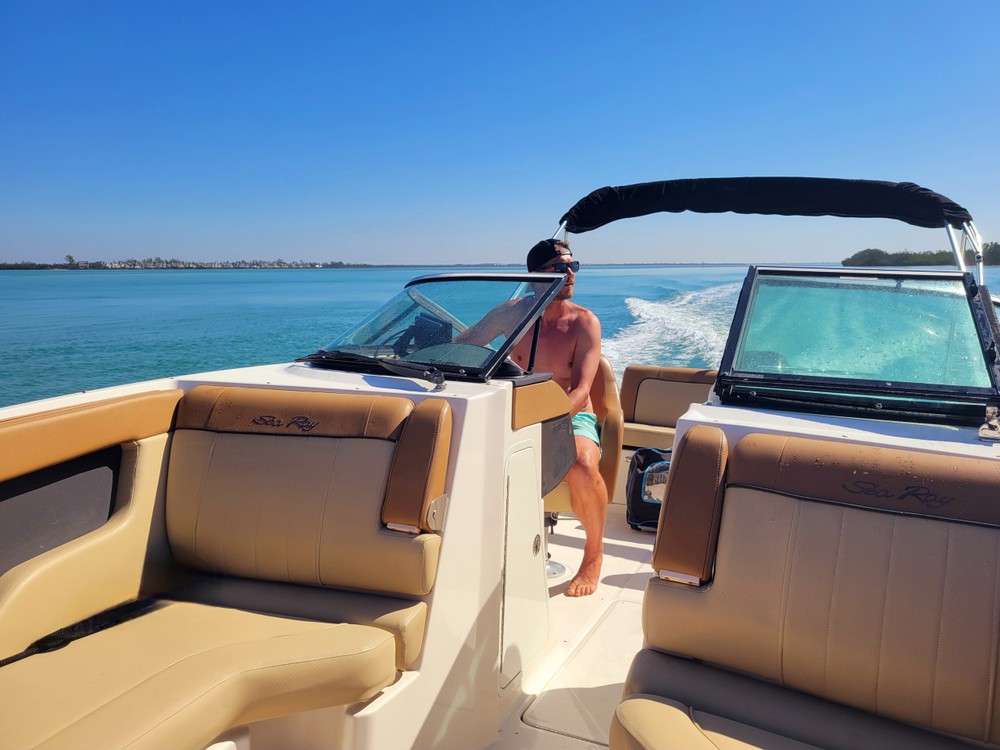 Woman standing at the helm of a bowrider with tan seating